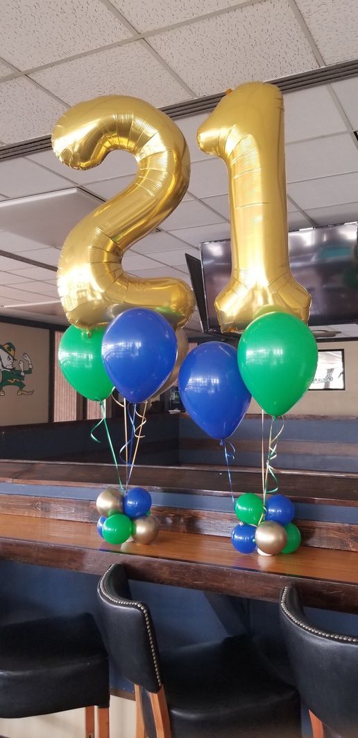 A table decorated with balloons and a gold number 21