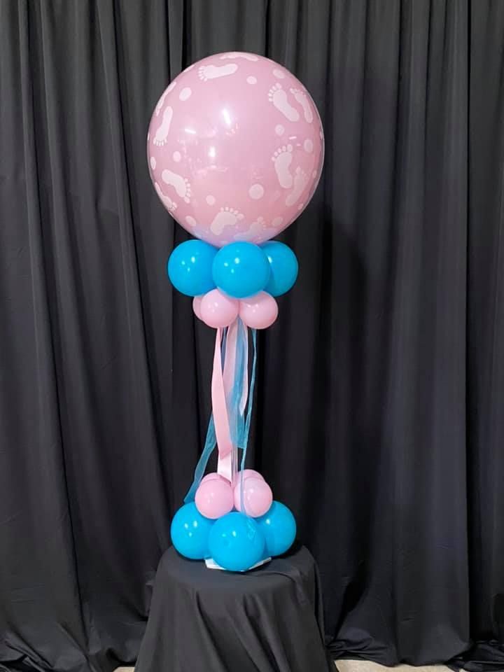 A pink and blue balloon sitting on top of a table.