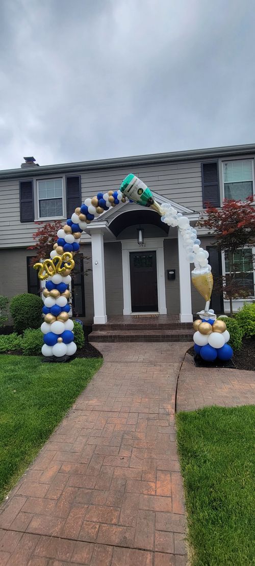 A house with a balloon arch in front of it.