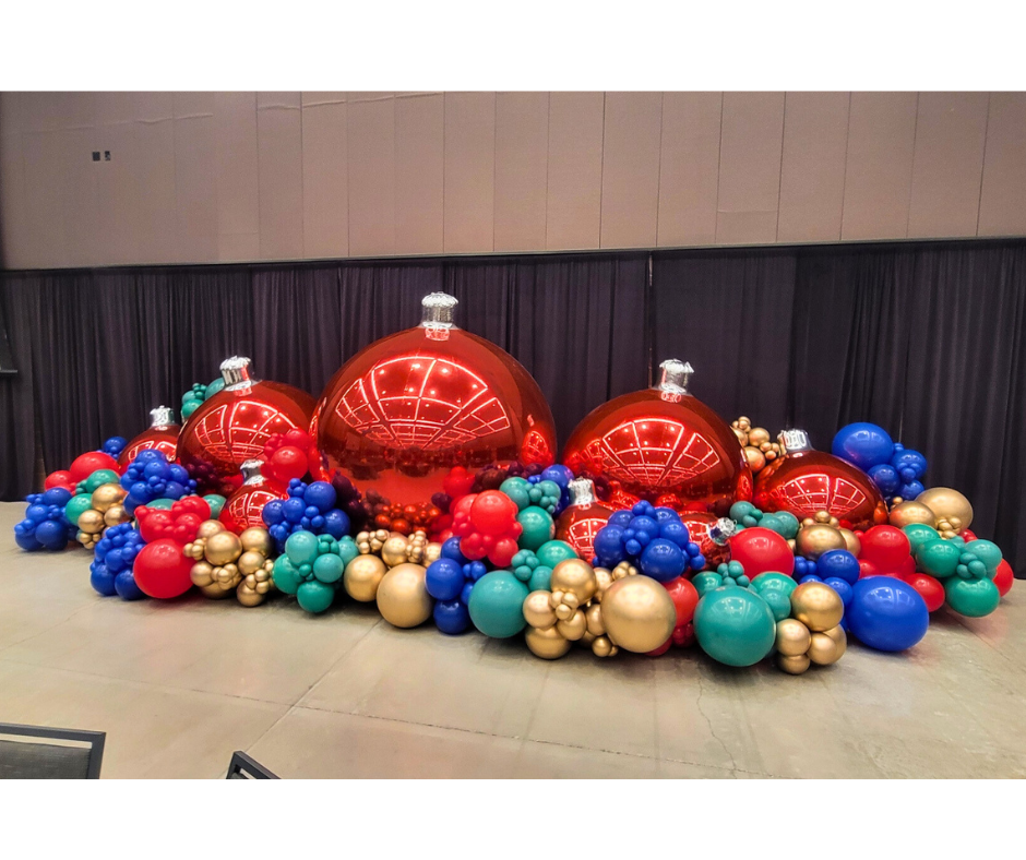 Christmas balloon display featuring large red ornaments surrounded by colorful balloons.