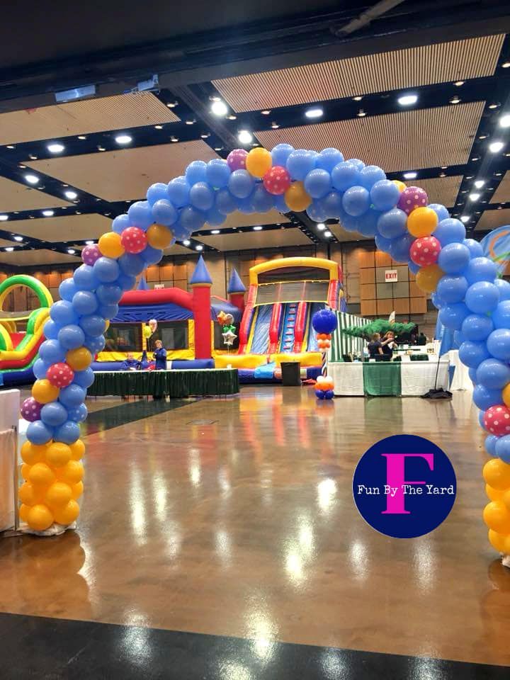 A large room filled with balloons and a bouncy house.