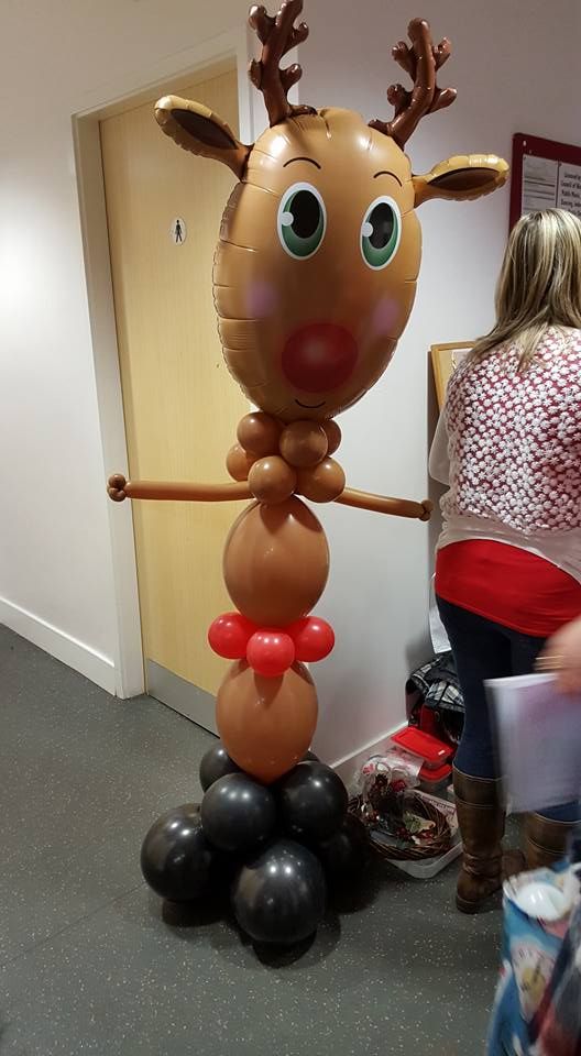A reindeer made out of balloons is standing in a hallway.