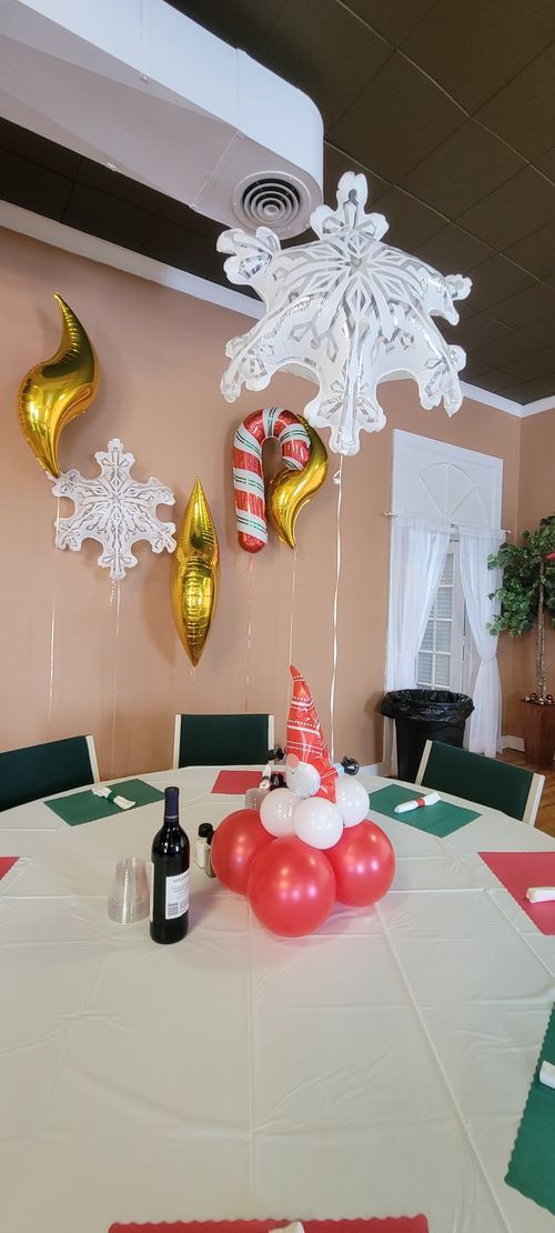 A table with a bottle of wine and balloons on it.