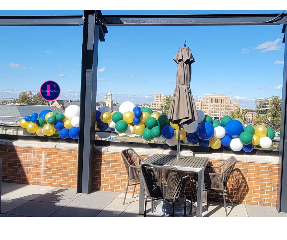 A patio with a table and chairs and balloons hanging from the ceiling