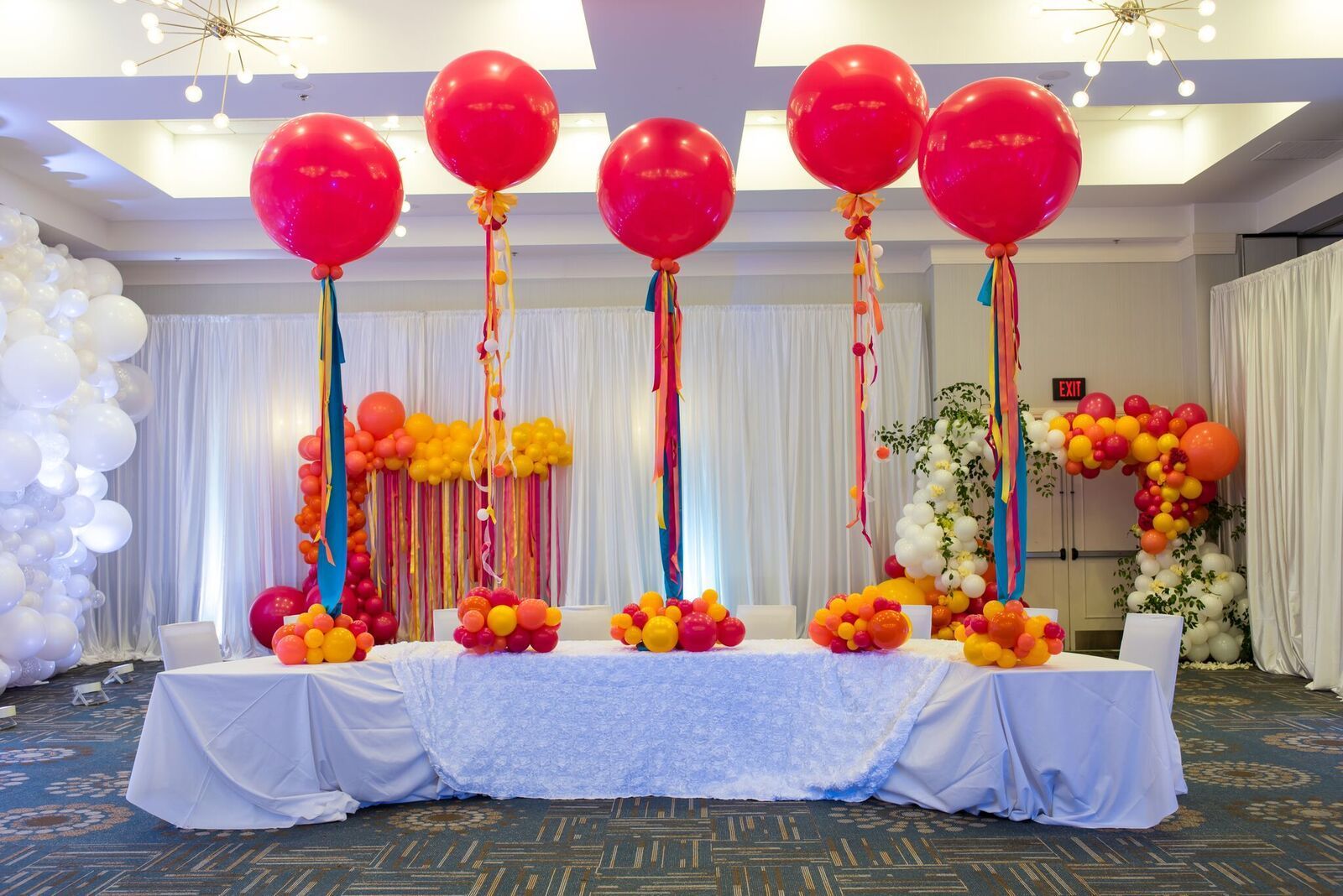 A room decorated with balloons and flowers for a party.