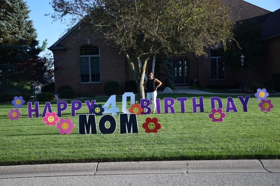 A happy 40th birthday mom sign in front of a house