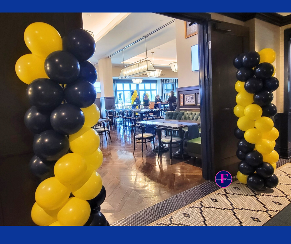 A restaurant with yellow and black balloons on the columns