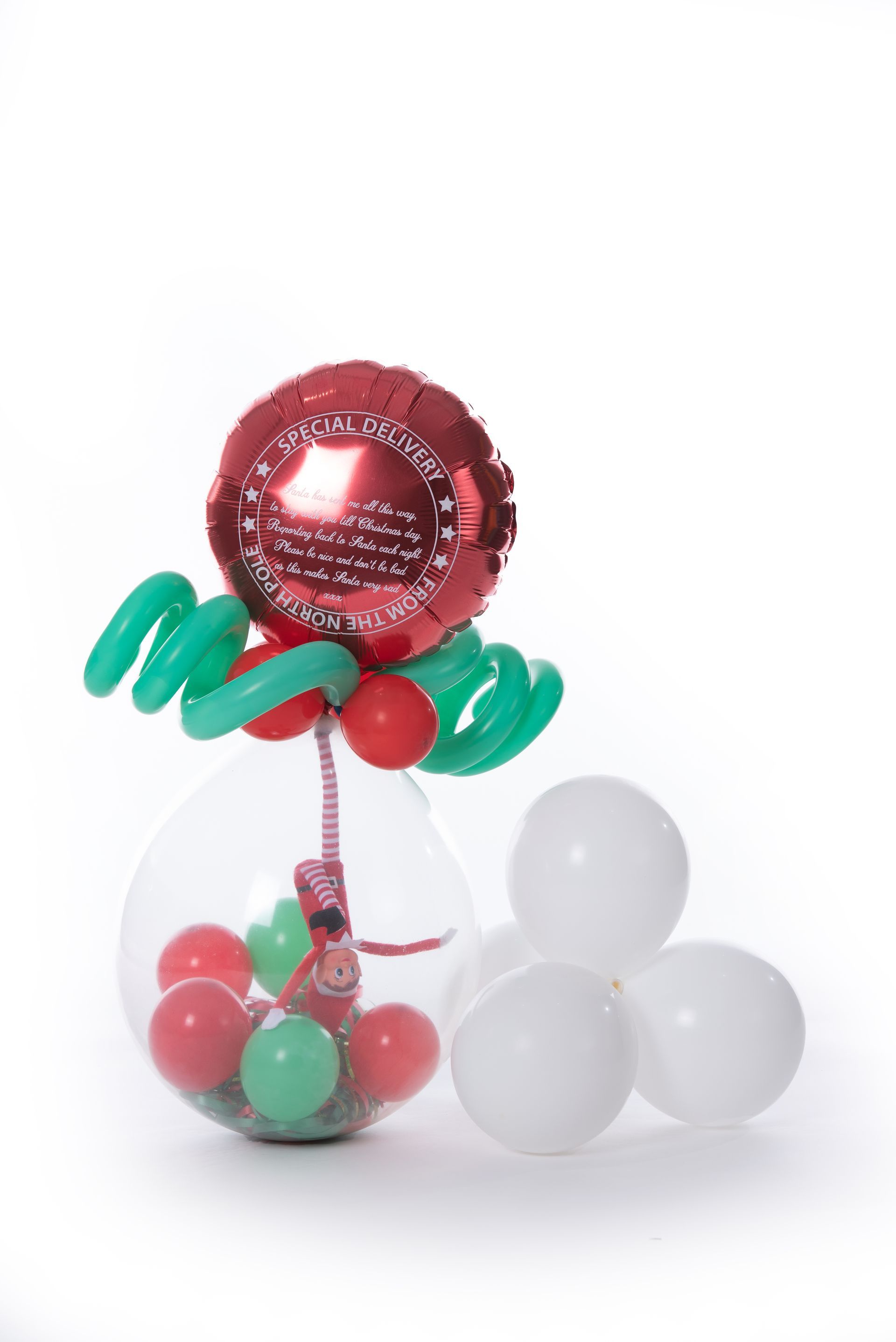 A red balloon is sitting inside of a clear balloon filled with balloons.