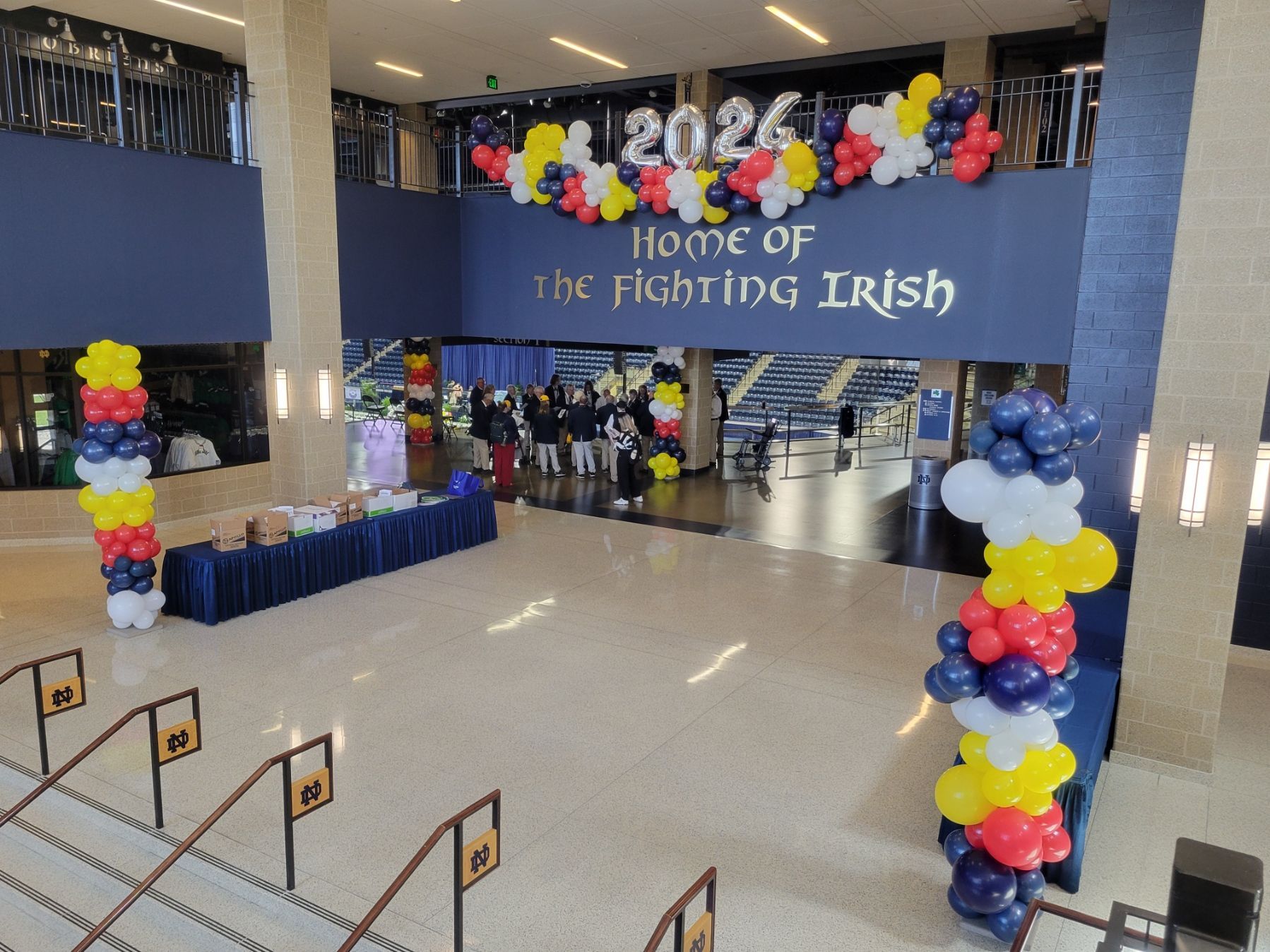 A large room with balloons and a sign that says `` home of the fighting irish ''