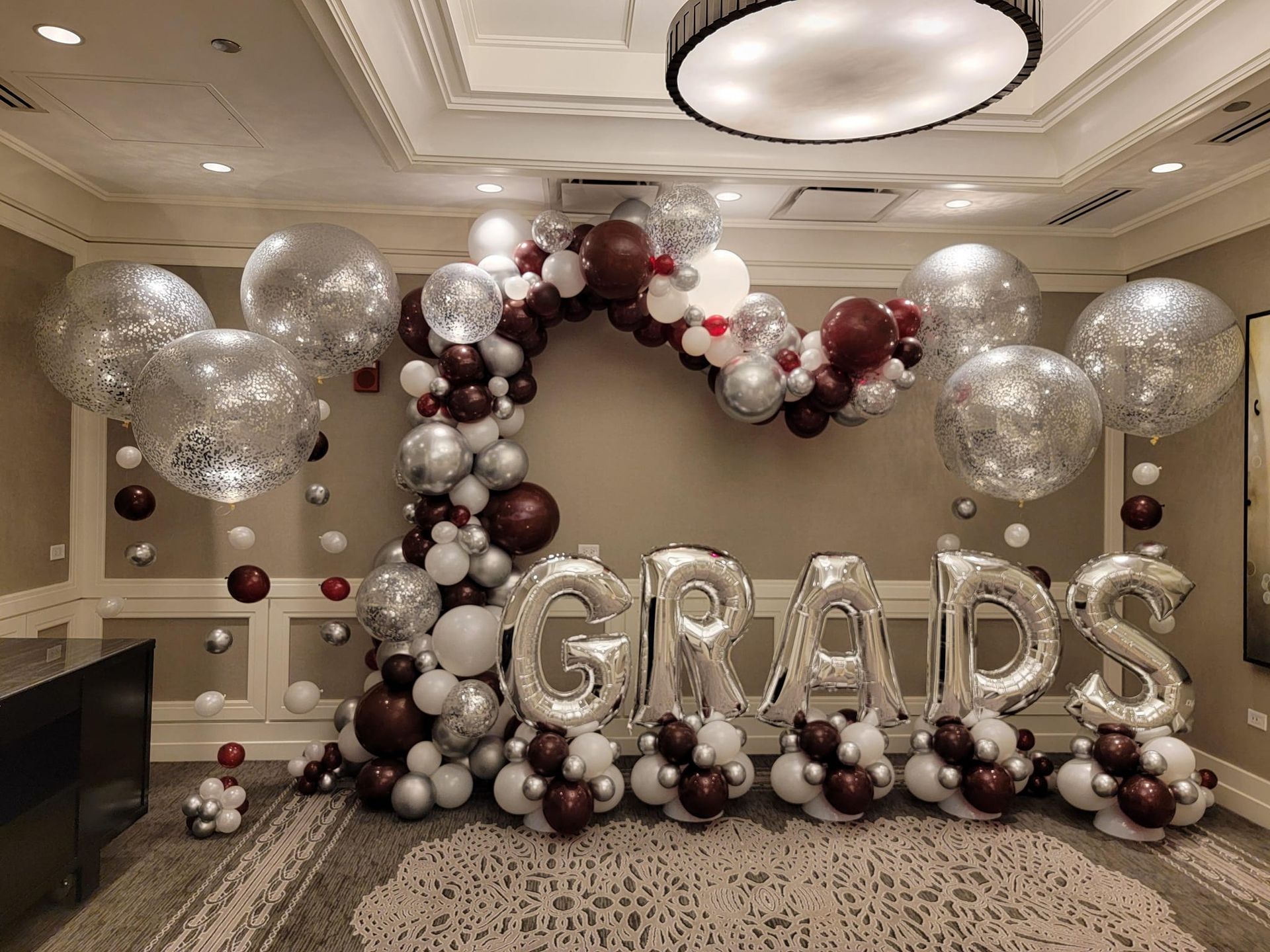 A room filled with balloons and a sign that says `` grads ''.