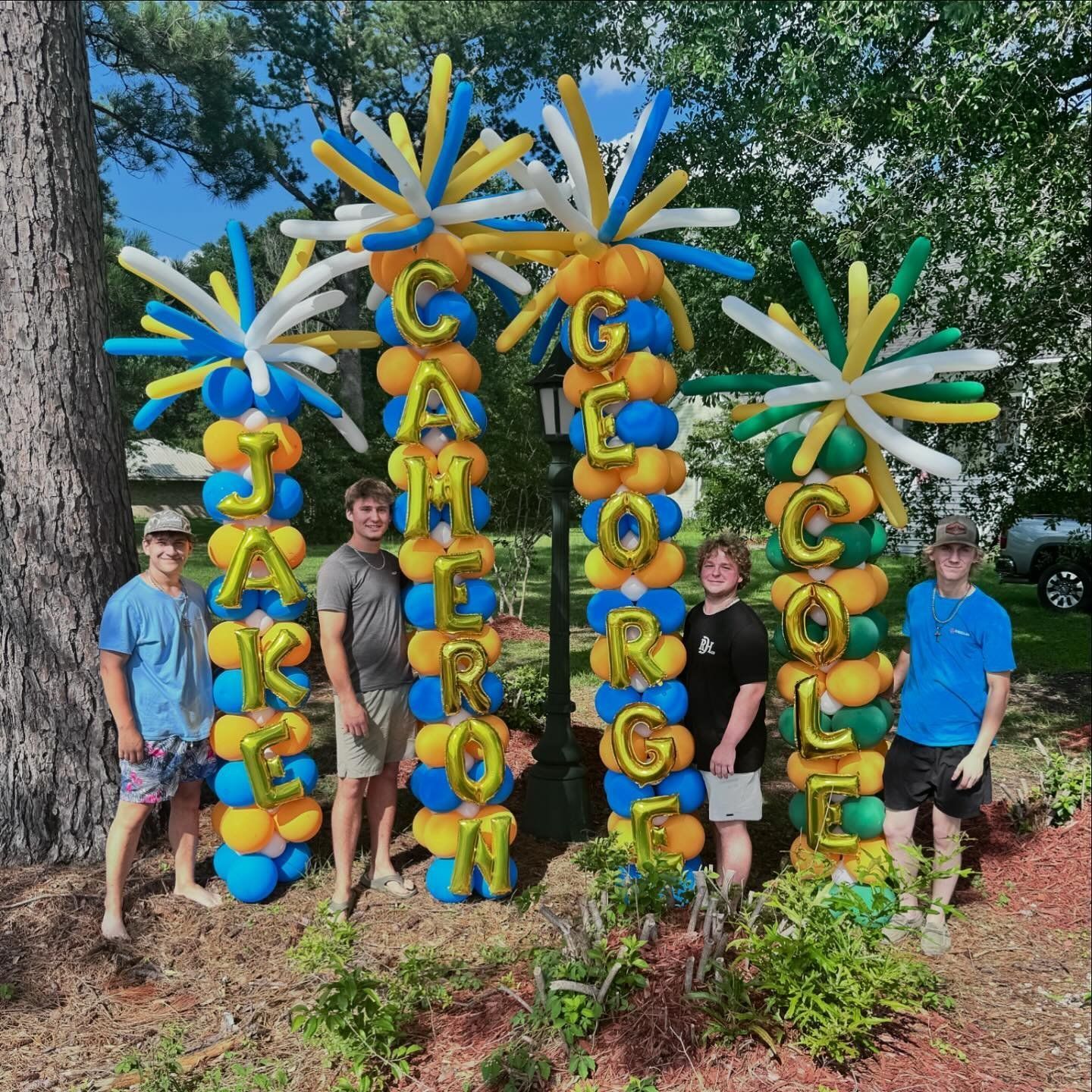 A group of people standing in front of balloons that say george