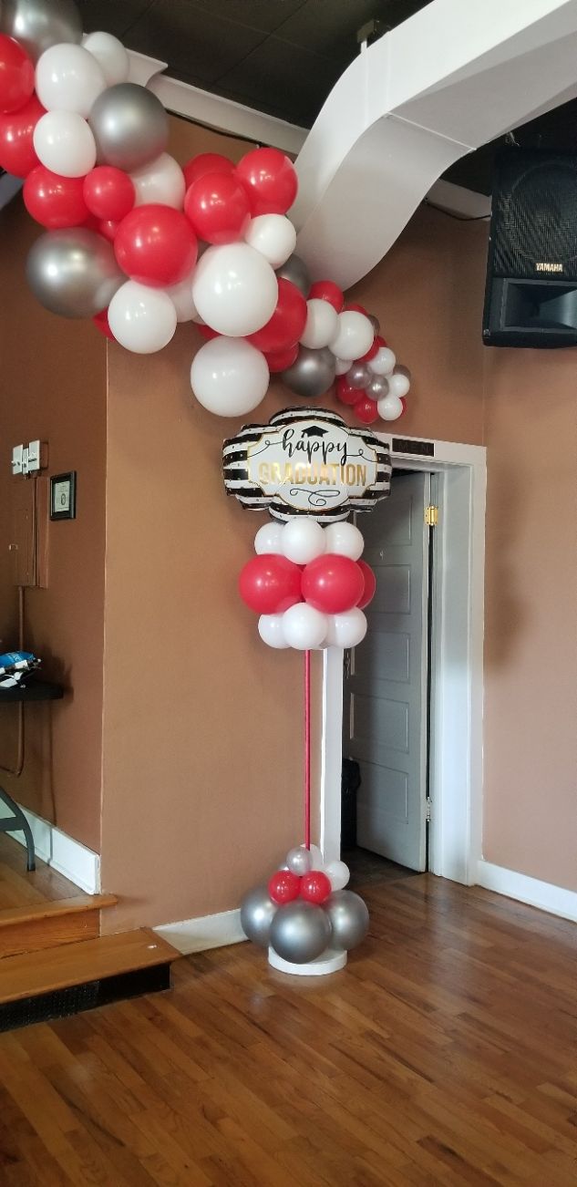 A room filled with red , white , and silver balloons.