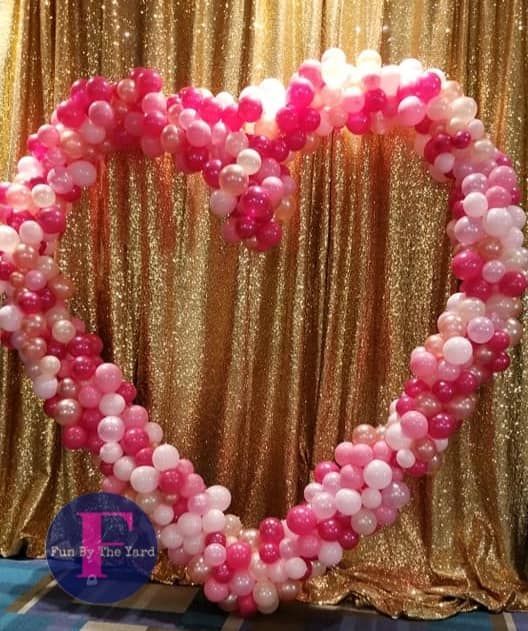 A heart made out of pink and white balloons