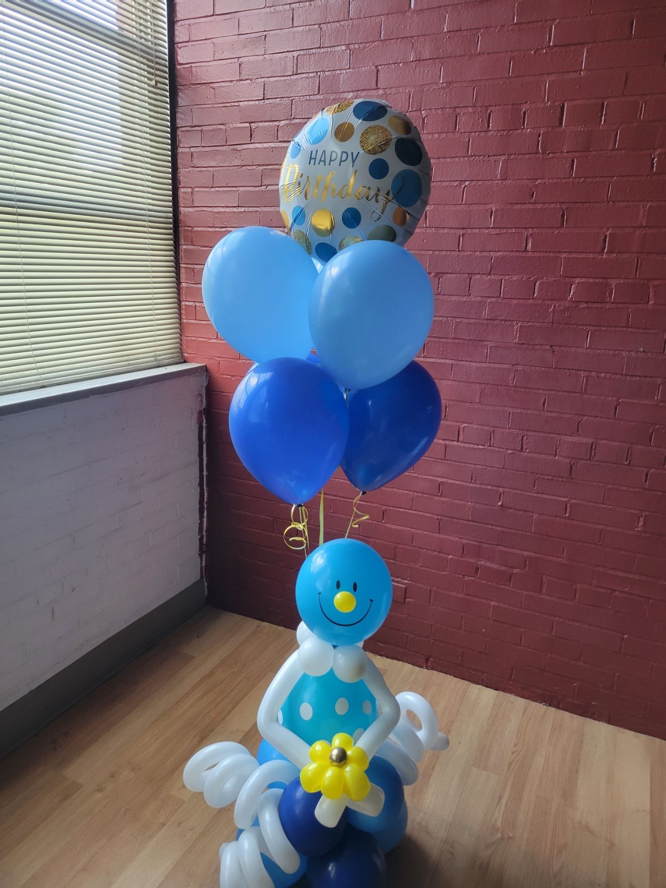 A bunch of blue balloons are sitting on top of a wooden floor. Hugable from Fun By The Yard