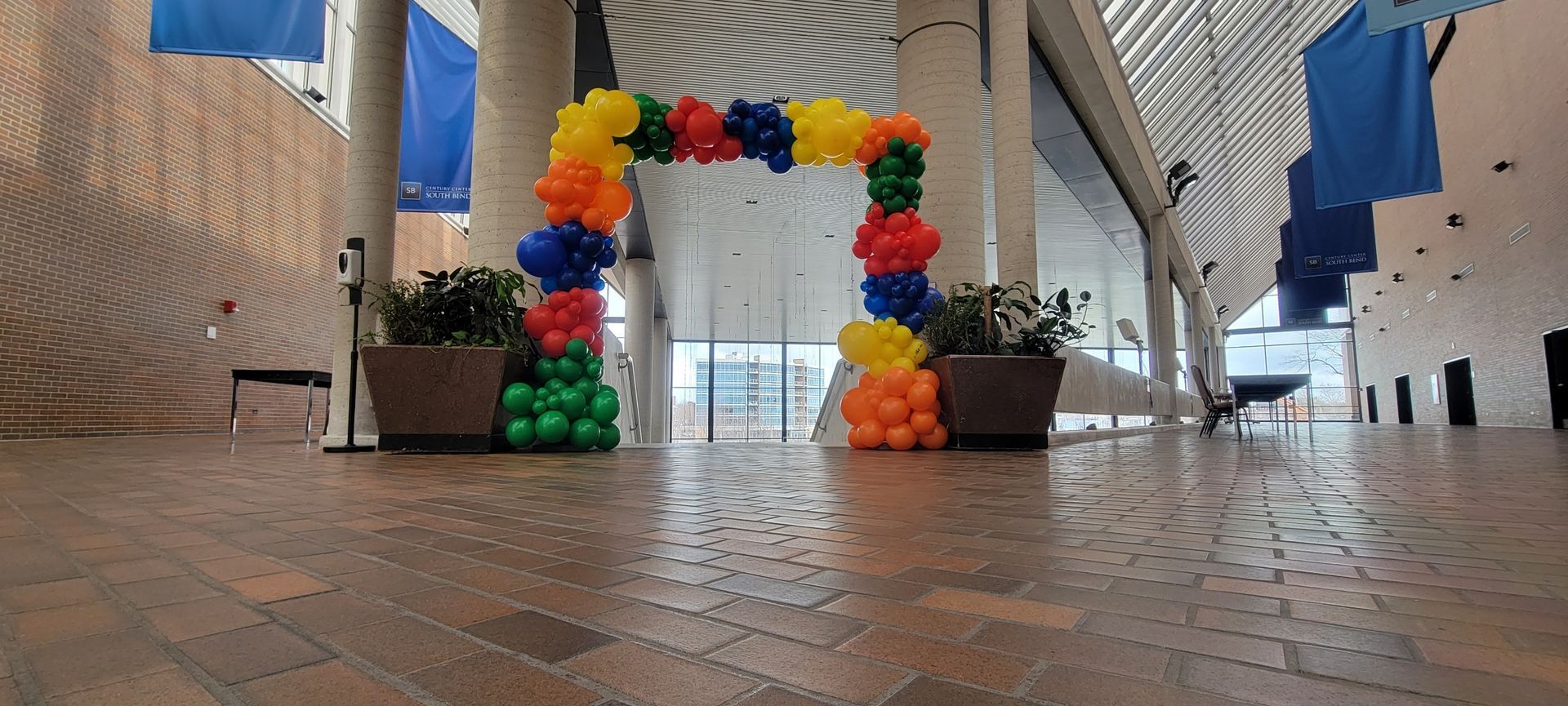 There is a large arch made of balloons in the middle of a hallway.