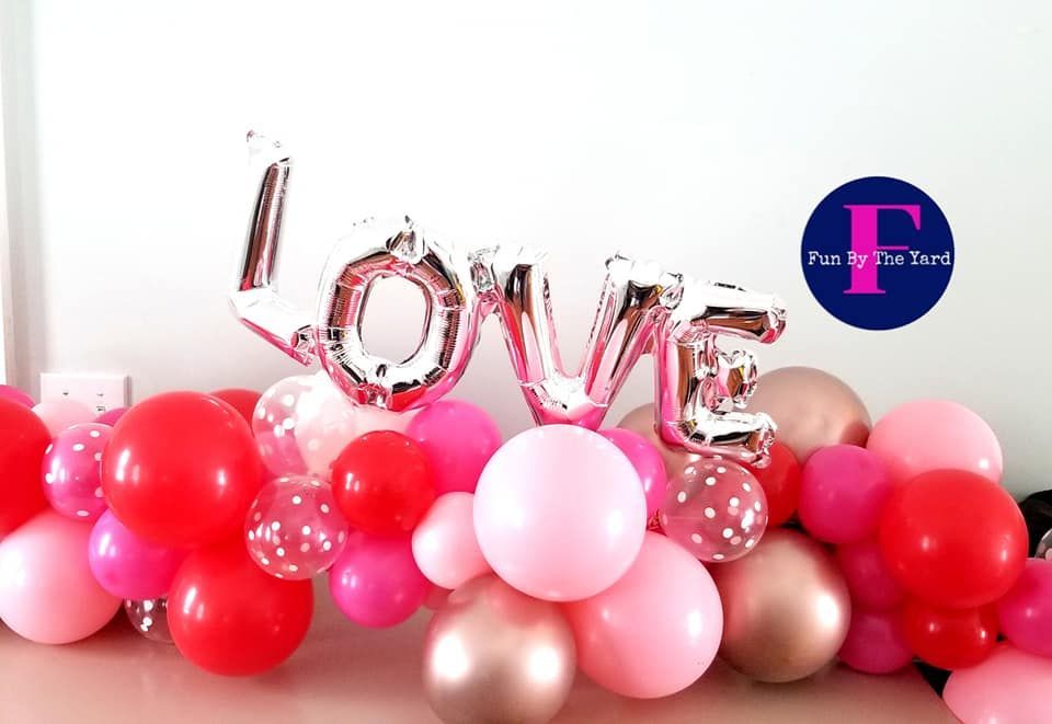 People releasing blue, white, and silver balloons at an indoor celebration.