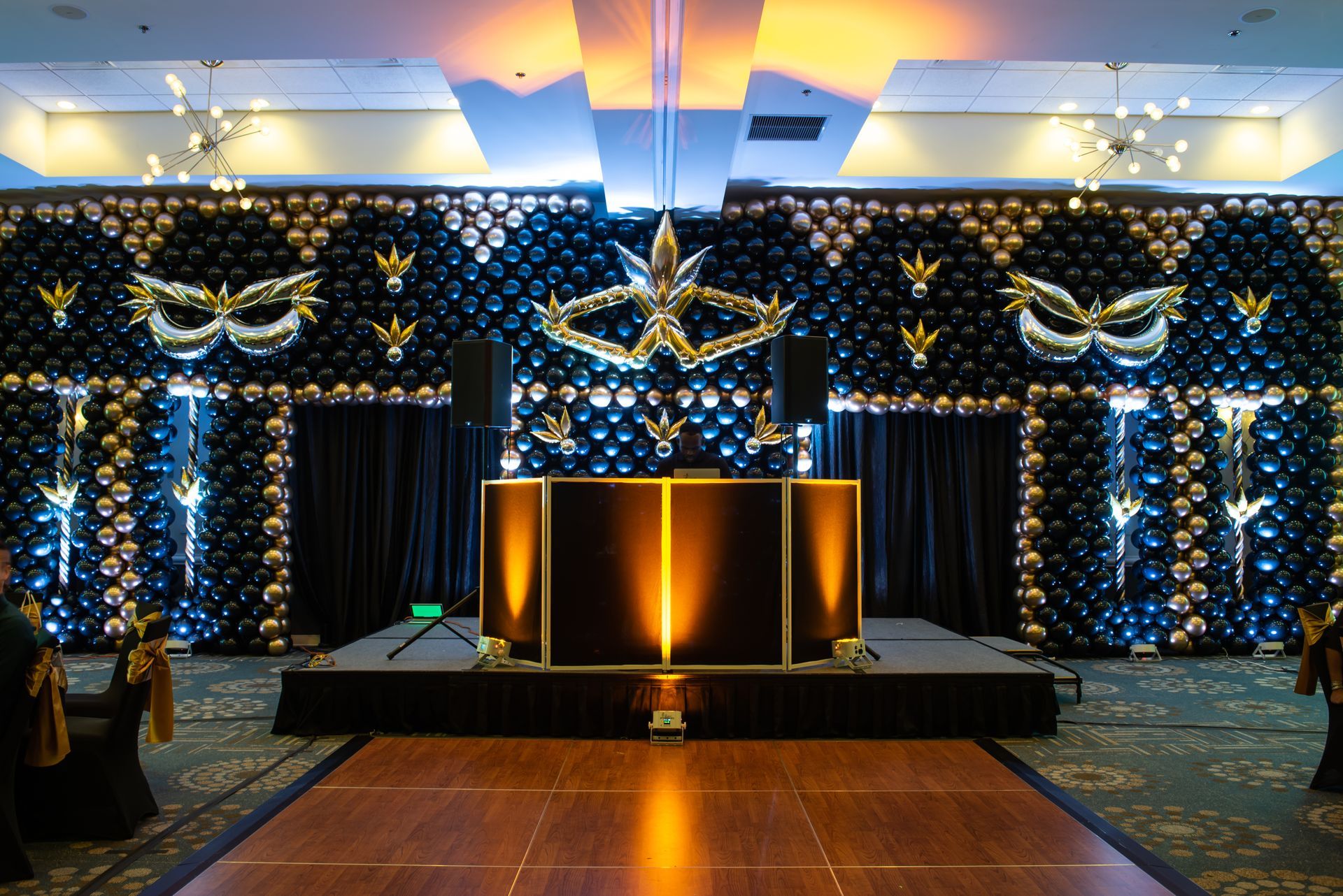 There is a dance floor in front of a wall of balloons for Mardi Gras