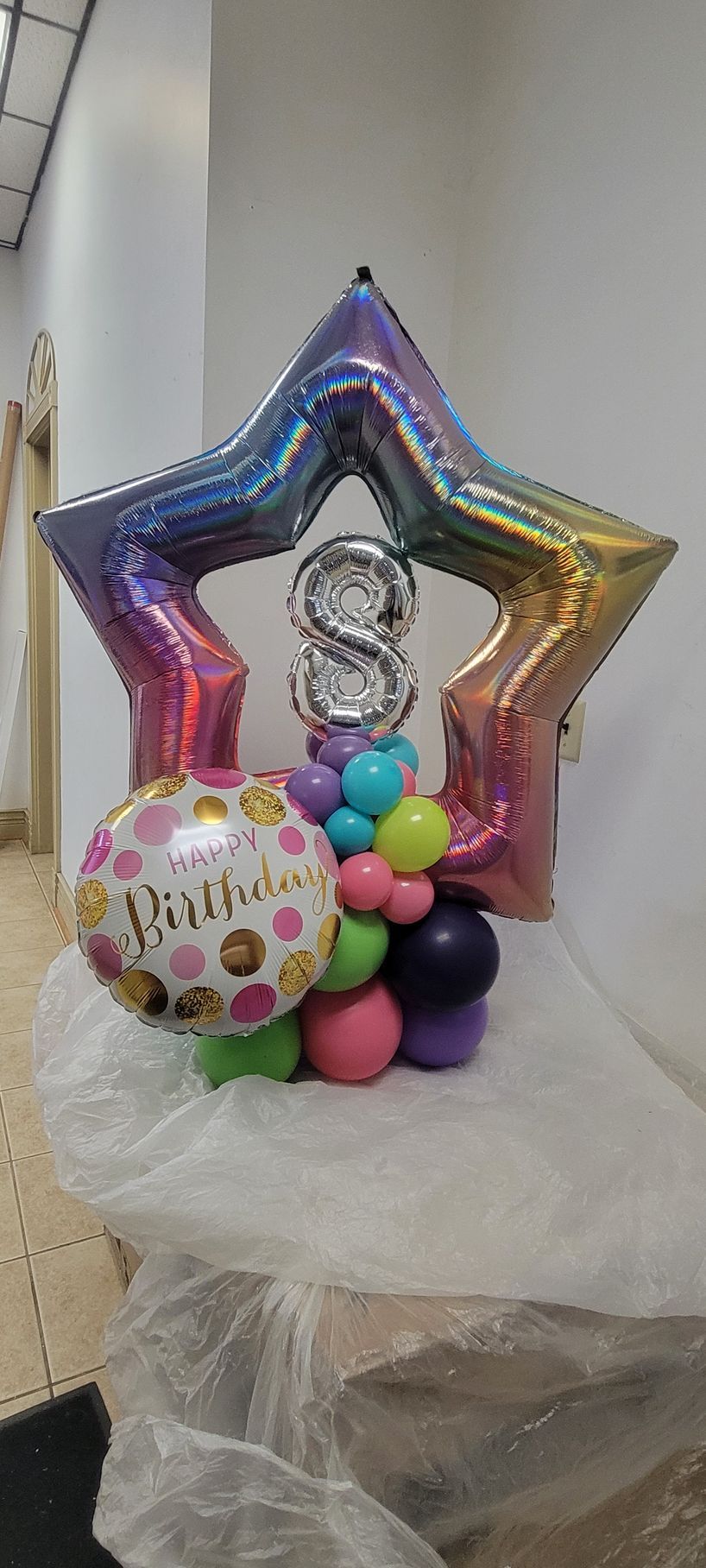 Colorful birthday balloon arrangement with a star, the number 8, and other balloons.