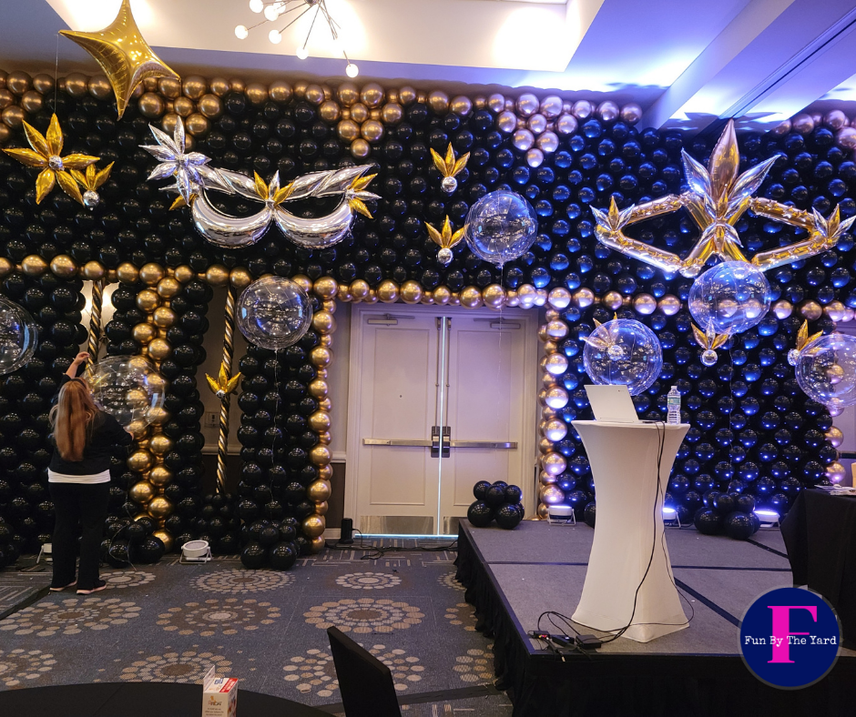 A room decorated with balloons and masks with the letter t in the corner