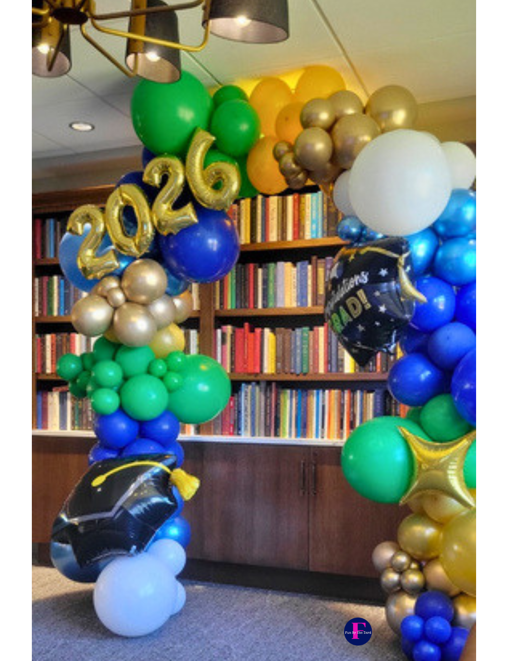 People releasing blue, white, and silver balloons at an indoor celebration.