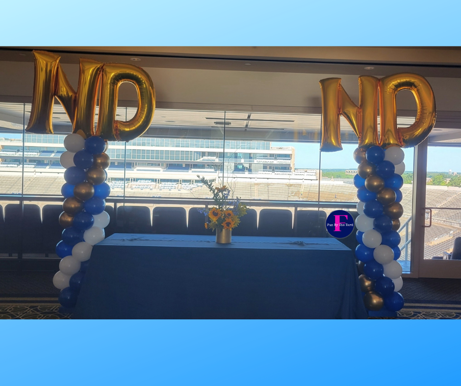 A table is surrounded by balloons and a sign that says nd nd.