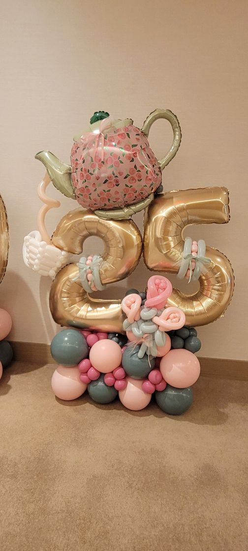 Balloon arrangement with the number 25, a teapot, and decorative balloons.