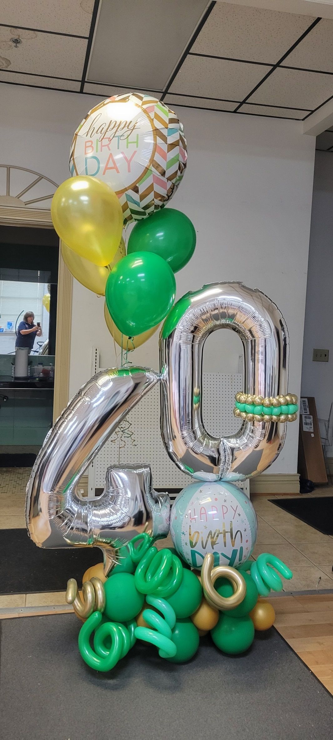 Balloon arrangement for a 40th birthday. Silver number balloons, green and gold balloons.