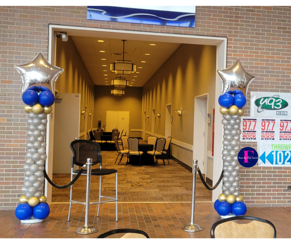 A room with balloon columns and a sign that says U93