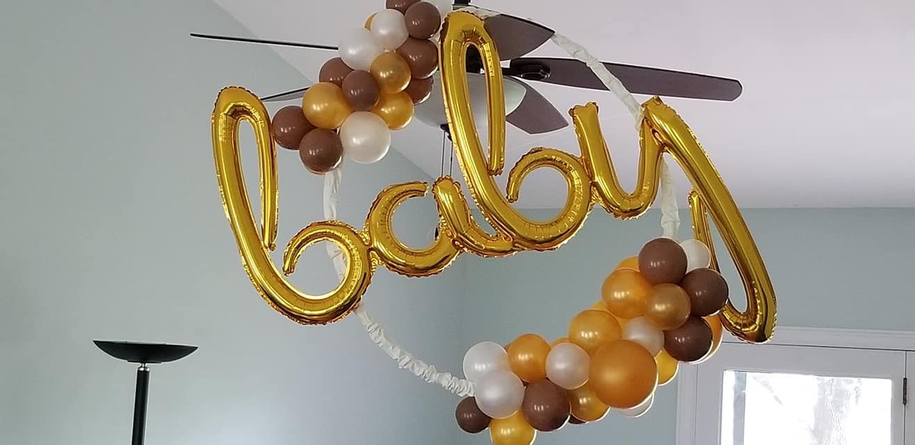 The word baby is written on a gold balloon hanging from the ceiling.