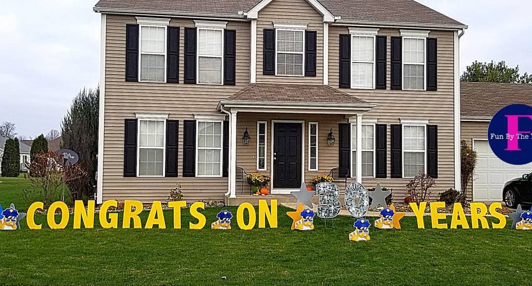 A house with a congratulations on years sign in front of it.