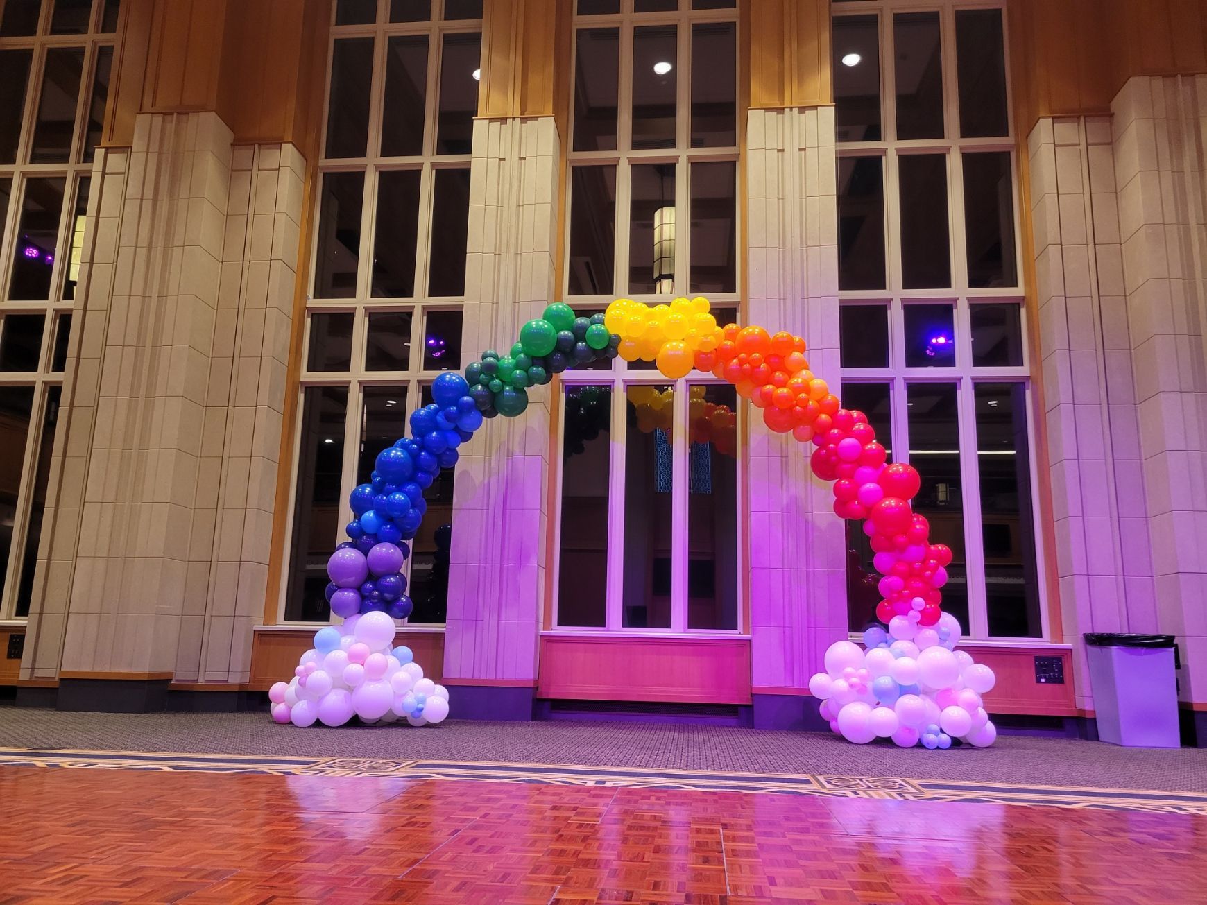 a rainbow made of balloons in front of a building
