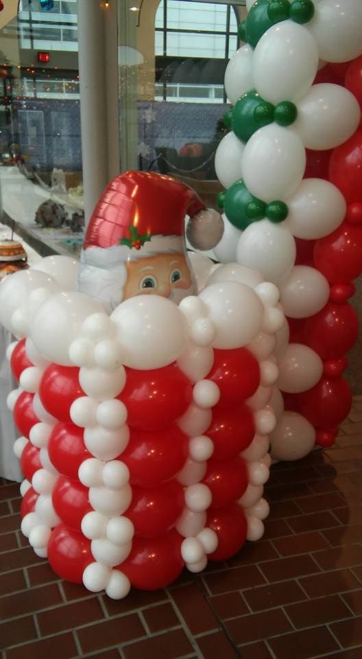 A santa claus made out of red and white balloons