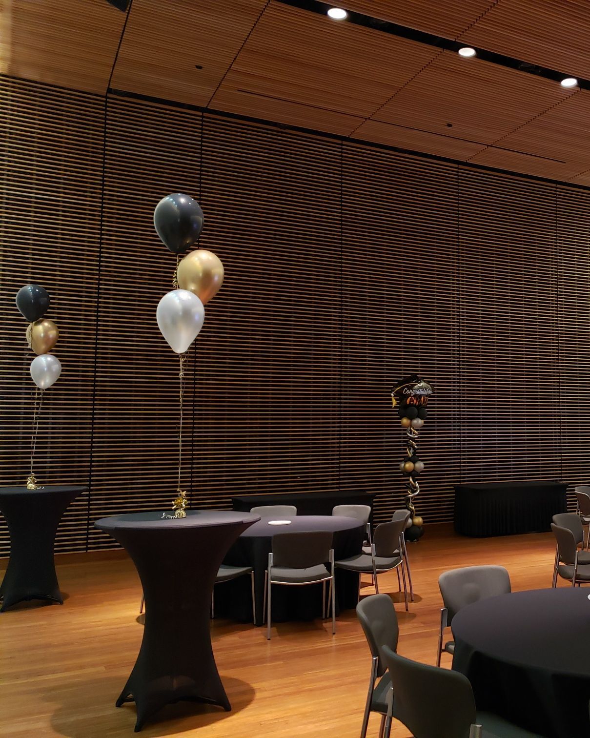 A room with tables and chairs and balloons hanging from the ceiling.