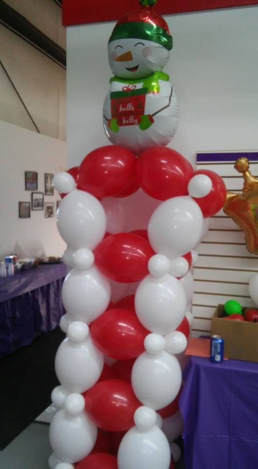 A column of red and white balloons with a snowman on top.