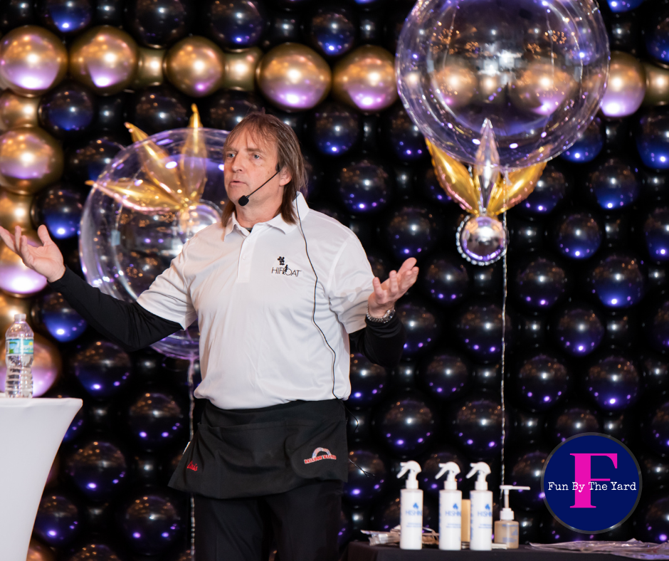 A man is standing in front of a wall of balloons