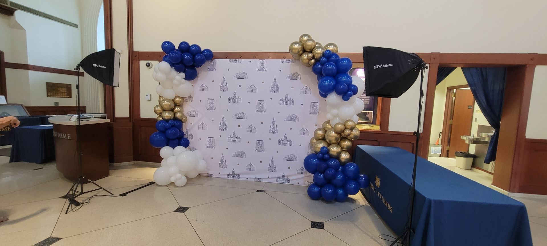 a room decorated with blue and gold balloons and tables