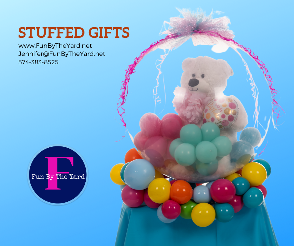 A stuffed gift with a teddy bear inside of balloons
