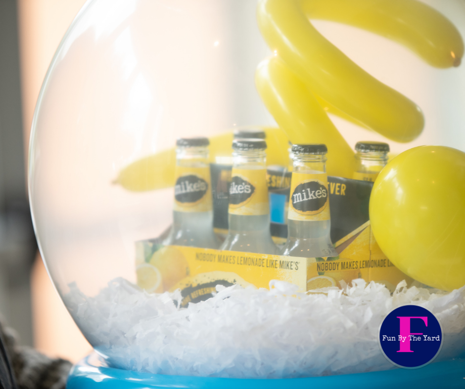 A snow globe filled with bottles of mikes lemonade.  Stuffed balloon gift