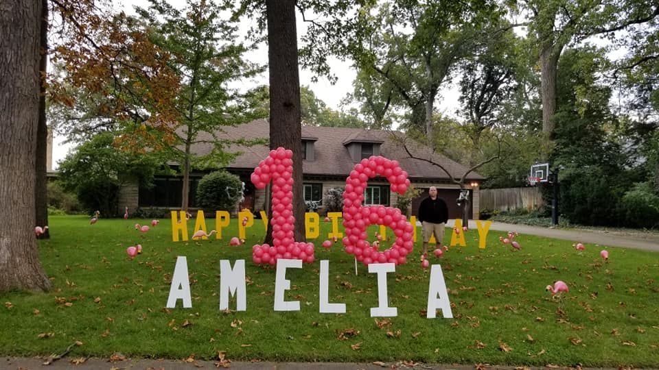 A sign that says happy 16th birthday amelia in front of a house
