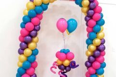 A bunch of colorful balloons are sitting on top of each other on a table.