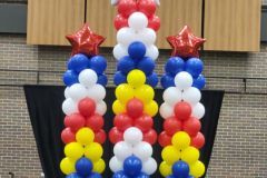 Three columns of red , white , and blue balloons with stars on them.