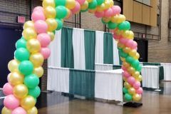 A large arch made of pink , yellow , and green balloons at Century Center.