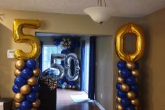 A room decorated with blue and gold balloons for a 50th birthday.