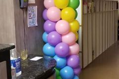 Balloon columns are stacked on top of each other in a hallway.