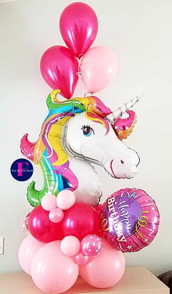Unicorn balloon bouquet with pink, magenta, and light pink balloons for a birthday.