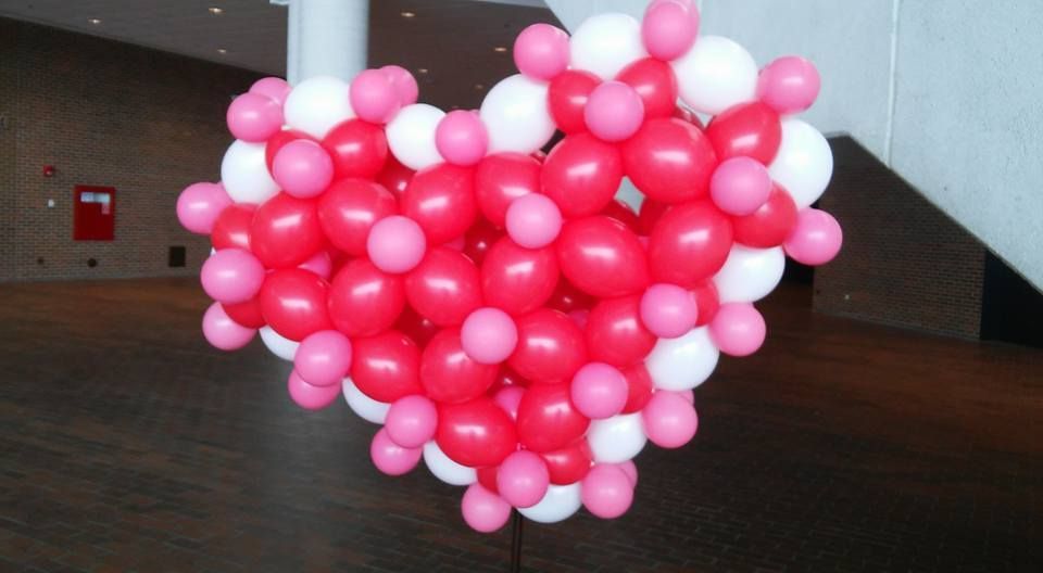 A heart made out of pink and white balloons