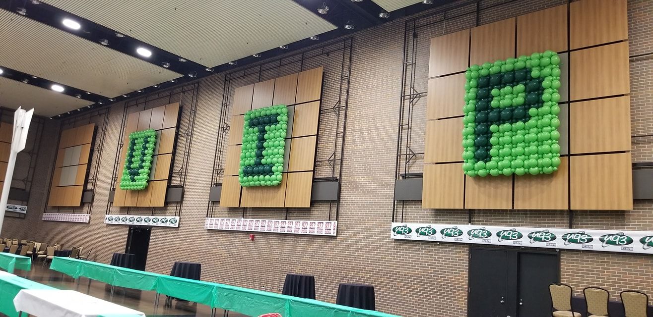 A large room with a lot of green balloons on the wall. VIP