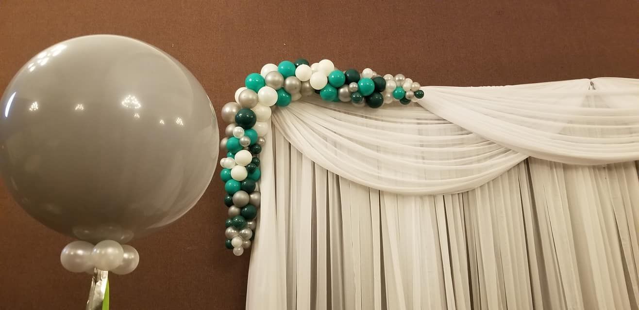 A large balloon is sitting in front of a white curtain.