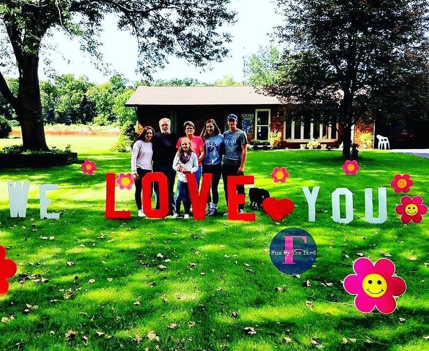 A group of people standing in front of a sign that says we love you