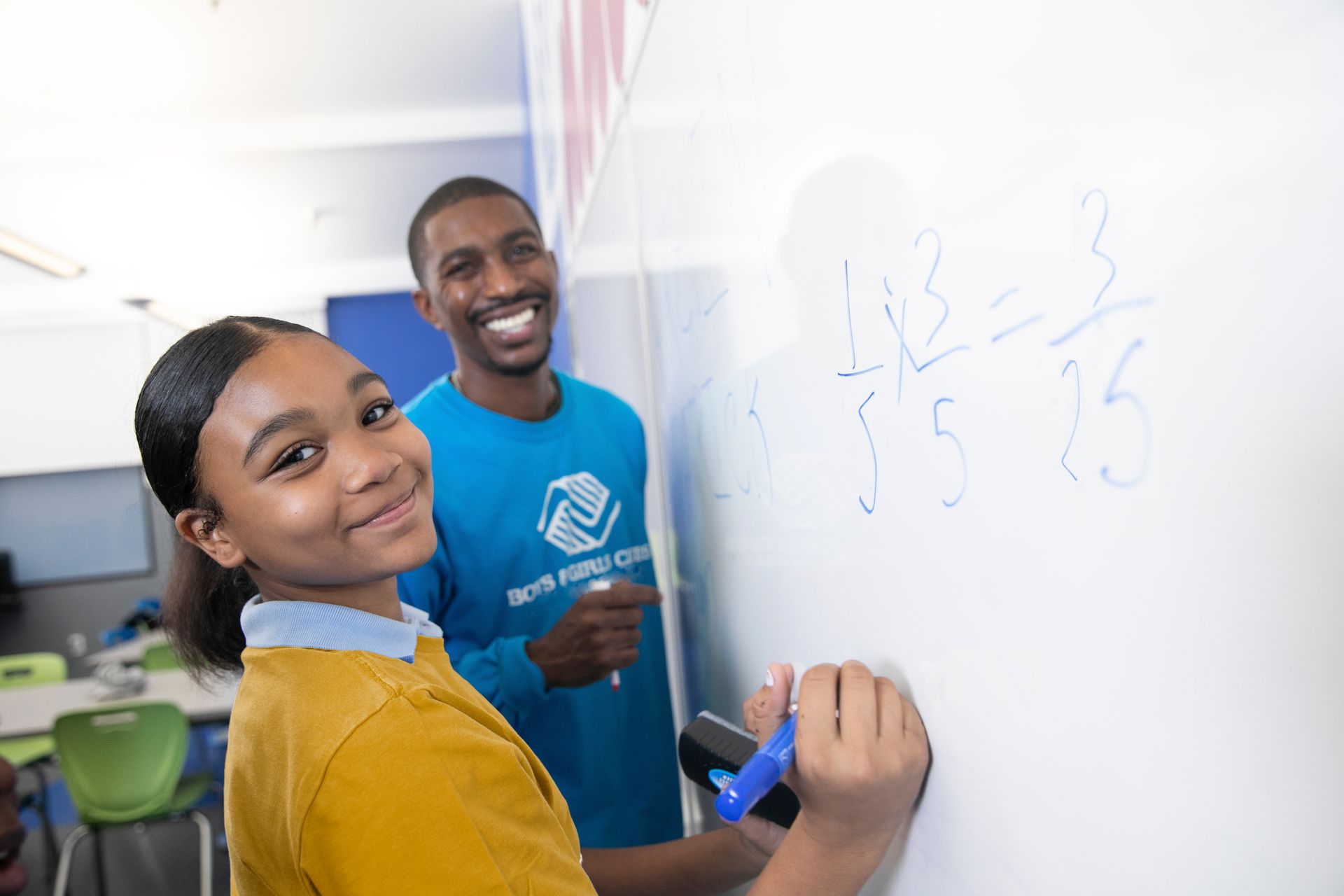 Two kids in blue boys and girls club shirts smiling at the camera.